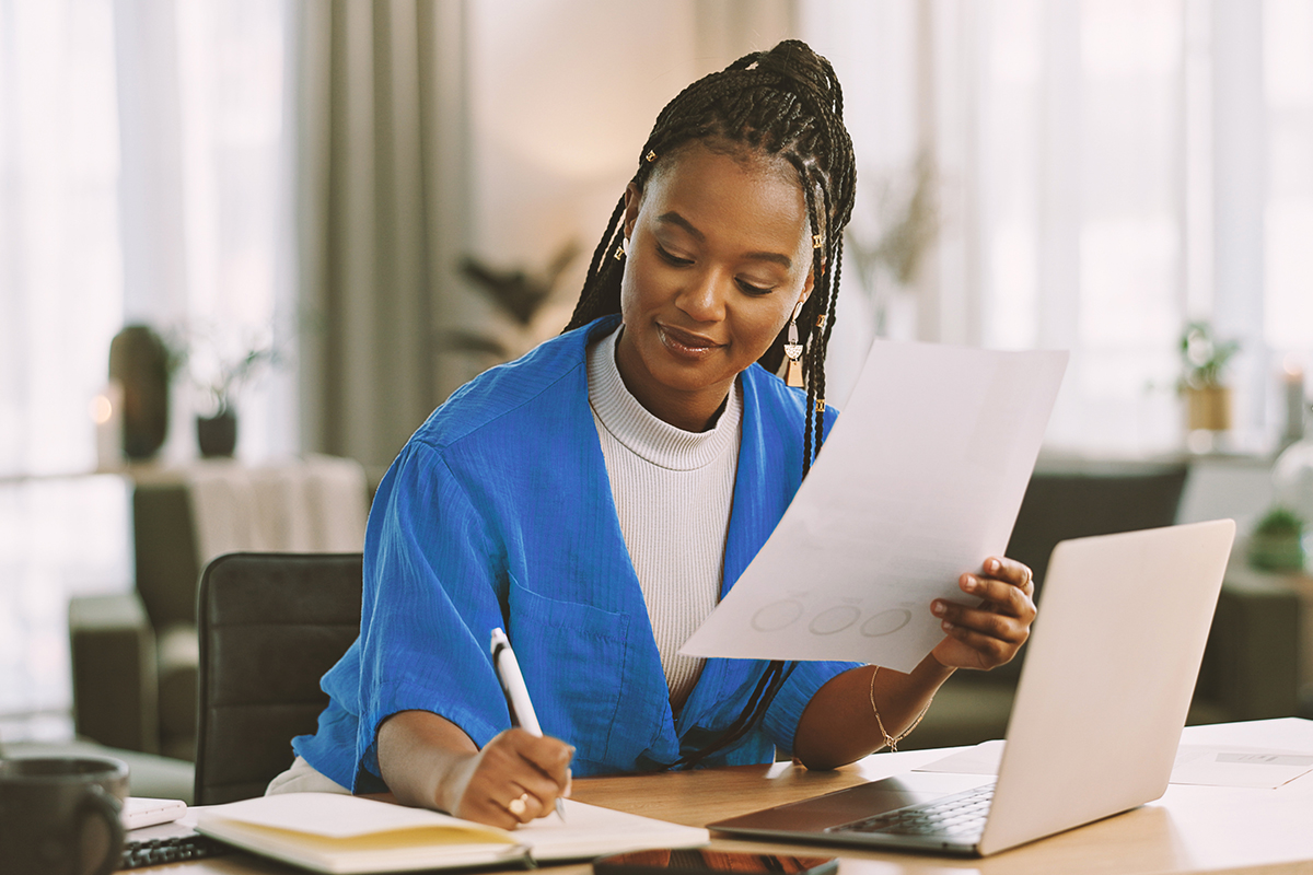 A woman doing paperwork at her laptop